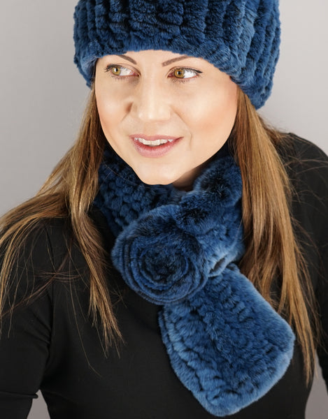 A person wearing a blue rex rabbit scarf 
paired with a matching blue hat.
